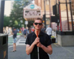 EarthGen青年研究员查尔斯·约翰逊在繁忙的人行道上摆姿势拍照.